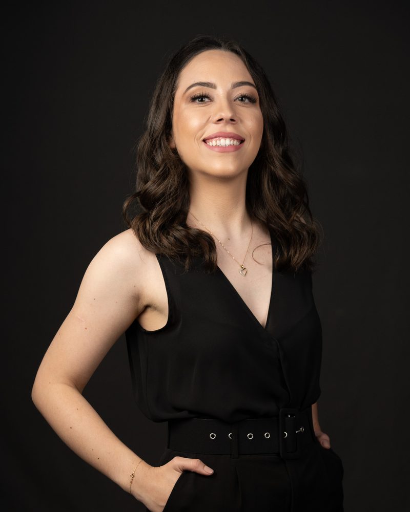 Dra. Isabelle Faoro sorrindo, de roupa preta